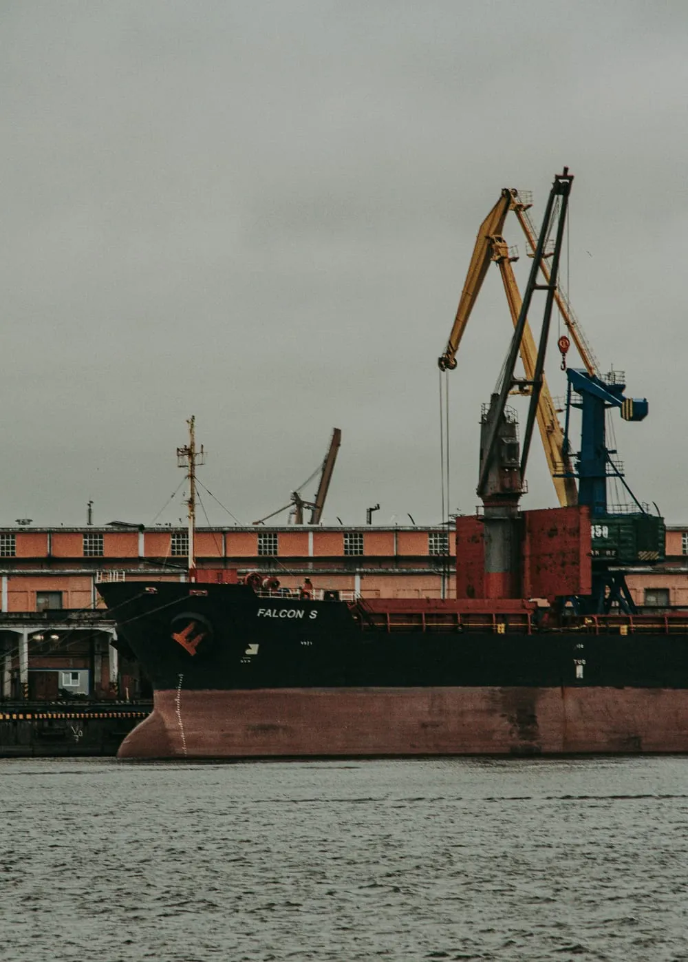 Cargo ship alongside port cranes